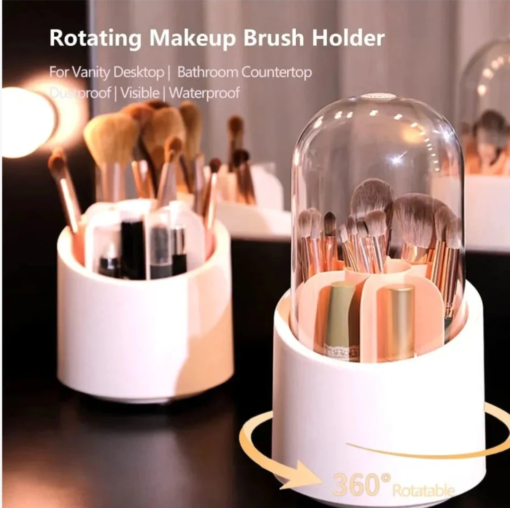 A hand lifting a clear dustproof lid off a white 360-degree rotating makeup brush organizer filled with various cosmetic brushes and lipsticks.