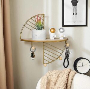 Modern gold metal semicircle floating wall shelf with a natural wood platform against a white wall.